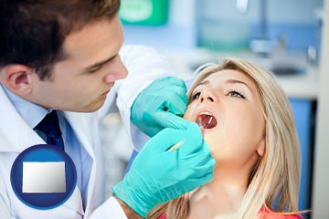 a dentist examining teeth - with Colorado icon
