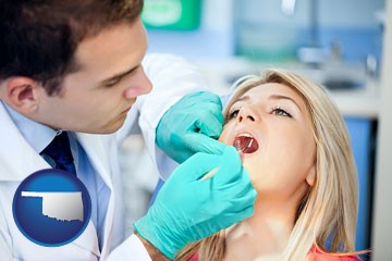 a dentist examining teeth - with Oklahoma icon