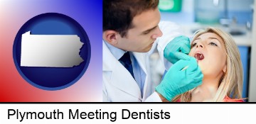 a dentist examining teeth in Plymouth Meeting, PA